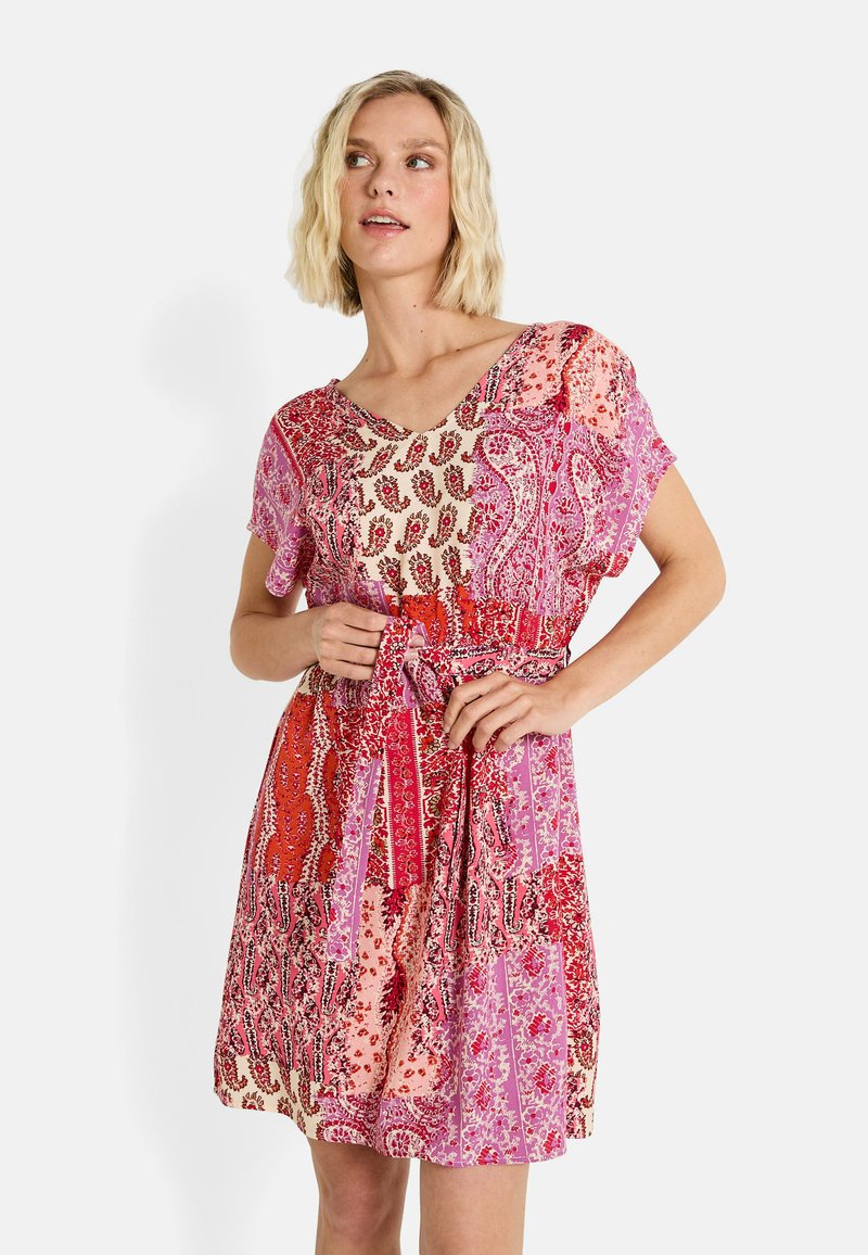 Vestido de manga corta con una mezcla de patrones de paisley en rojo, rosa y crema, con la cintura ceñida y un escote en V. Tejido ligero.