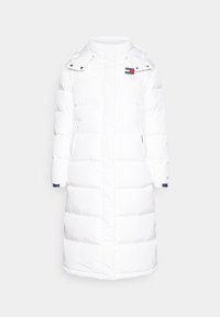 Vit puffjacka med rakt snitt, hög krage och tryckknapsdetaljer. Har marinblå muddkragar och två sidofickor.