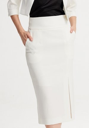 Jupe crayon blanche avec une texture lisse, taille haute et poches latérales. Présente une fente avant pour faciliter le mouvement.