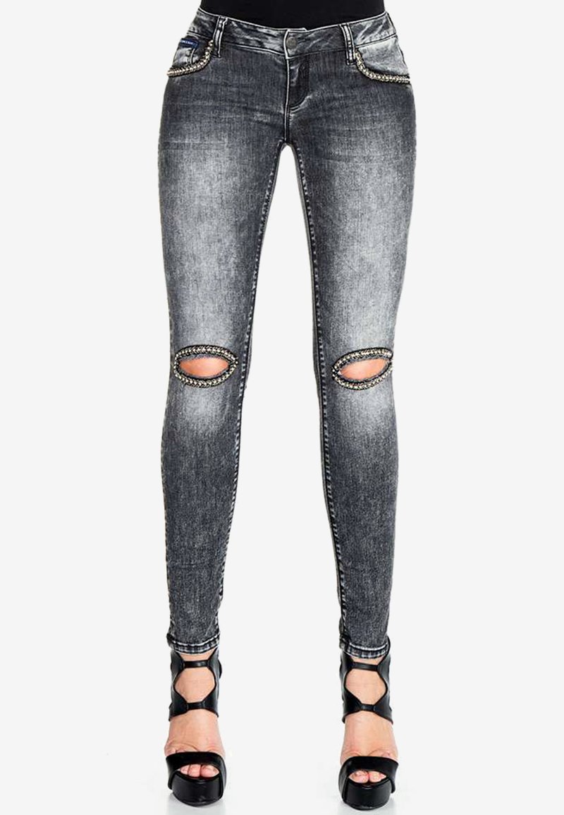 Enganliegende Jeans in ausgewaschenem schwarzen Denim mit ausgefransten Knie-Ausschnitten, versehen mit detaillierten Nähten und verzierten Taschen. Hoch geschnittenes Design.