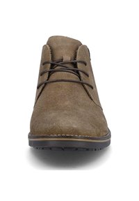Bottines chukka en daim marron avec bout arrondi, fermeture à lacets et semelle en caoutchouc contrastante avec des détails de couture. Texture douce et design simple.