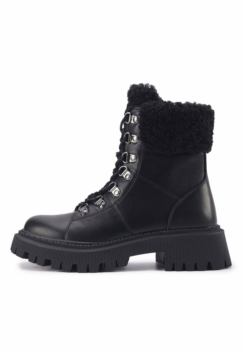 Bottine en cuir noir avec semelle épaisse à crampons, laçage avant avec crochets métalliques et revers en shearling noir.