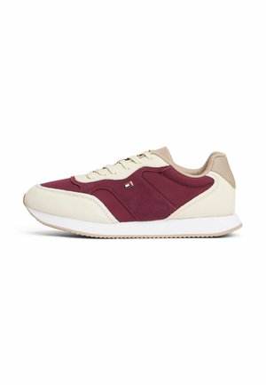 Sneakers z kremową cholewką, burgundowymi akcentami z zamszu, beżowymi detalami, białą podeszwą i małym logo po bocznej stronie.