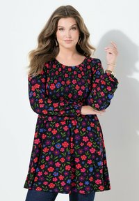 Czarna sukienka w kwiaty z długimi rękawami, z żywymi różowymi, niebieskimi i zielonymi wzorami. Teksturowana góra i rozkloszowany krój spódnicy.
