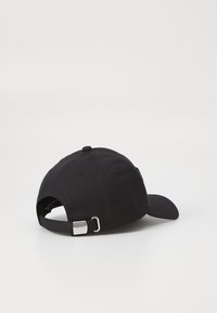 Casquette noire en coton, avec une visière courbée, une sangle réglable avec boucle en métal, et des coutures à l'arrière.