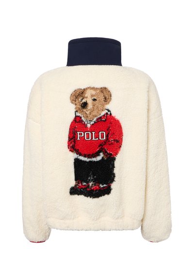 Cream fleece jacket with navy collar and a teddy bear wearing a red Polo sweater embroidered on the back.