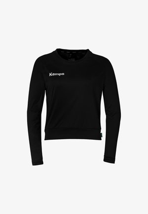 Haut de sport noir à manches longues avec un col ras du cou, présentant un tissu à texture subtile et un logo "Kempa" blanc sur la poitrine.