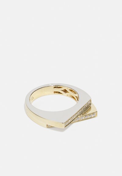 Anillo cruzado de oro y plata con un diseño geométrico, textura suave y una fila de pequeñas piedras transparentes en uno de los bordes.