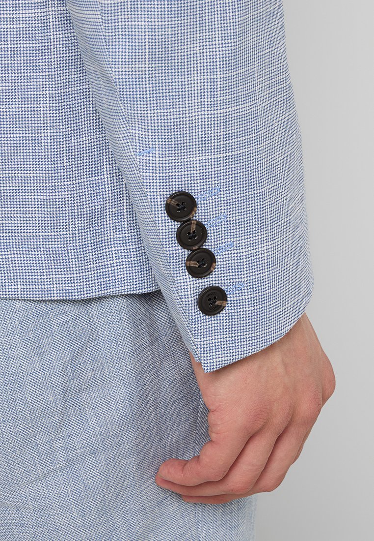 Blazer checkered blu chiaro con un tessuto texturizzato. Presenta quattro bottoni neri sul polsino e una manica a taglio dritto.