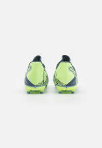 Botas de fútbol en un brillante verde lima y azul marino, con una superficie texturizada, un diseño elegante y una suela con tacos multicolores para mayor tracción.