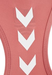 Roze stof met drie witte naar beneden wijzende chevron-pijlen in een verticale rij en zichtbare stiksels aan de zijkanten.