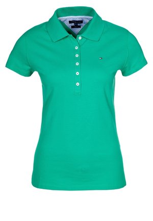 Zielona koszulka polo z krótkim rękawem, kołnierzykiem, pięcioma białymi guzikami i małym logo Tommy Hilfiger po lewej stronie klatki piersiowej.