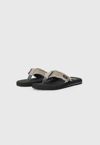 Flip-flops featuring a gray textile strap with frayed edges, black rubber sole, and a subtle logo on the side. Flat design, minimalistic style.