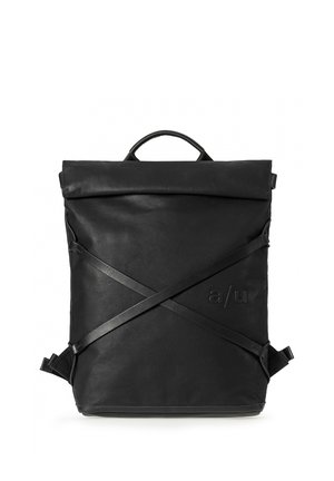 Zaino quadrato in pelle nera con manico superiore, spallacci regolabili incrociati sul davanti e logo "a/u" impresso nell'angolo inferiore destro.