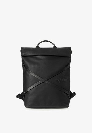 Schwarzer quadratischer Lederrucksack mit einem Tragegriff oben, gekreuzten verstellbaren Riemen auf der Vorderseite und geprägtem "a/u"-Logo in der unteren rechten Ecke.