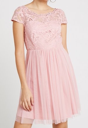 Robe courte rose clair avec corsage en dentelle florale et manches courtes transparentes, associée à une jupe plissée en tulle.