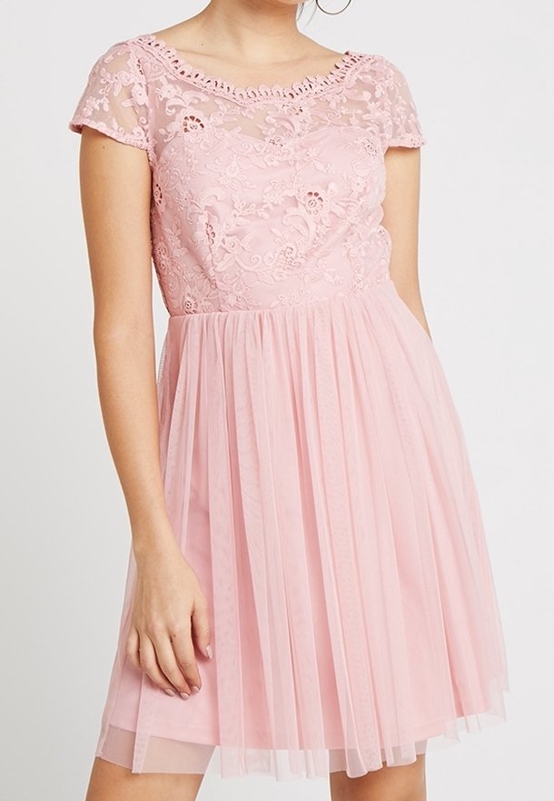 Robe courte rose clair avec corsage en dentelle florale et manches courtes transparentes, associée à une jupe plissée en tulle.