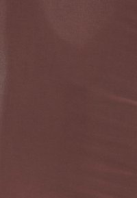 Burgundy tyg med en jämn, något glänsande yta, som visar subtila variationer i nyans och glans över ytan.