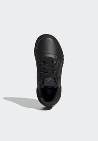 Chaussure de sport noire avec une tige en cuir texturé, bout rond, design à lacets, logo sur la languette et semelle en caoutchouc avec motif.