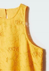 Żółty top bez rękawów z kwiatową haftem, teksturowaną powierzchnią i wycięciem w kształcie klucza na plecach, wykonany z gładkiej, lekkiej tkaniny.