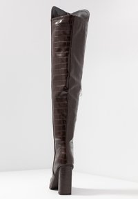Brun faux krokodille-læder over-knæ støvle med vinkelret top, blank finish, tyk blokhæl og detalje med lynlås på siden.