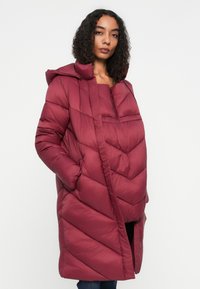 Cappotto imbottito bordeaux con cappuccio, caratterizzato da un motivo a zig-zag, tasche laterali e apertura frontale, che offre una vestibilità comoda e calore.