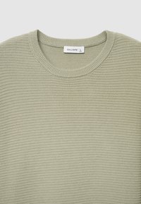 Maglione verde chiaro con trama, scollo rotondo e polsini a costine, realizzato in materiale morbido, con etichetta recante la scritta "CALLIOPE L."