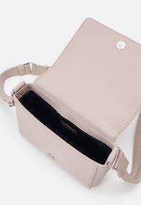 Tommy Jeans CITY BOLD FLAP CROSSOVER - Taška s příčným popruhem - drifty dunes