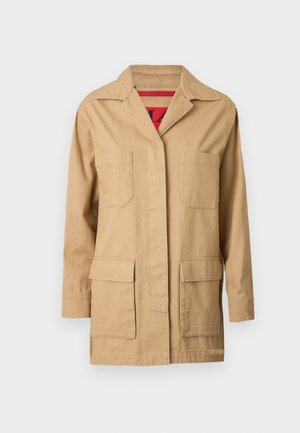 Beige canvas jacket with a collared neckline, two chest pockets, and two lower side pockets. Inside features a red patterned lining.
