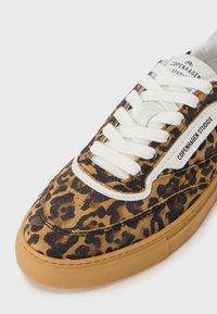 Baskets en daim à imprimé léopard avec lacets blancs, semelle en caoutchouc gomme et détail logo. Caractérisées par un bout arrondi et une surface texturée.