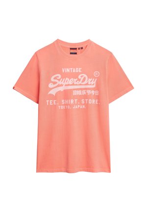 Koraalkleurig katoenen T-shirt met korte mouwen, ronde halslijn en witte bedrukte tekst "Vintage SuperDry T-shirt Winkel Tokio, Japan."