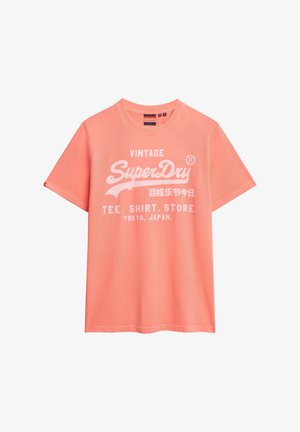 Koraalkleurig katoenen T-shirt met korte mouwen, ronde halslijn en witte bedrukte tekst "Vintage SuperDry T-shirt Winkel Tokio, Japan."