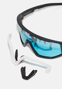 Sportzonnebril met een zwart frame en blauw getinte lenzen. Inclusief verwisselbare neuspadjes in wit en zwart voor een verstelbare pasvorm.