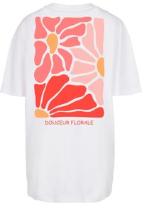 Weißes T-Shirt mit floralen Motiven in roten, rosa und orangenen Farbtönen auf dem Rücken, mit dem Text "DOUCEUR FLORALE" darunter.