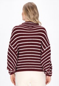 Gestreifter, weinroter und weißer Pullover mit lockerer Passform, weiten Ärmeln und gerippter Textur. Besitzt einen hohen Kragen und leicht ballonförmige Ärmel.