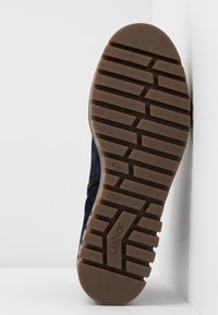 Semelle de chaussure avec des crampons rectangulaires profonds, taille 4½, nom de la marque "Gabor" visible sur la semelle extérieure en caoutchouc.