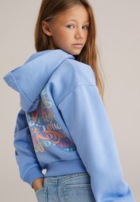 Sweat à capuche bleu clair avec un grand motif graphique multicolore au dos. Comprend une capuche spacieuse et des poignets côtelés. Style décontracté.