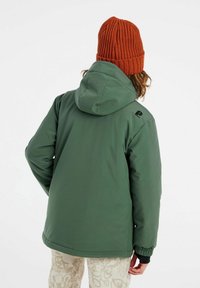 Veste isolée verte avec capuche, dotée de poignets élastiques et d'un accent logo. Associée à un bonnet en tricot orange texturé et à un pantalon à motifs.