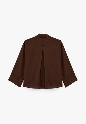 Bruine, gestructureerde shirt met een rugplooien en een kraag. Lange mouwen met manchetten. Eenvoudig ontwerp, geen zichtbare hardware of accenten.