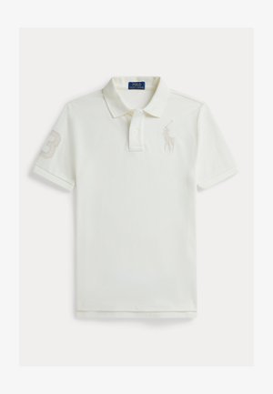 Hvit poloskjorte laget av bomull med korte ermer, med tallet tre på venstre erme og en liten logo på brystet i en lysere nyanse.