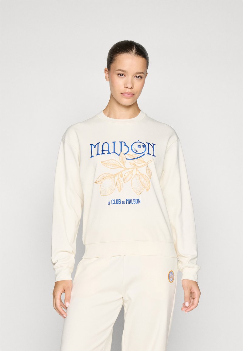 Felpa crema realizzata in tessuto morbido, con la scritta "MAIBON" in blu e oro e una grafica di limone e foglia sul davanti.