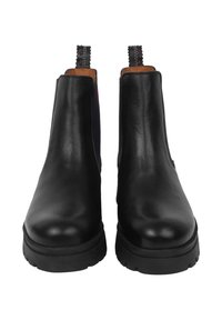 Stivali ankle in pelle nera con pannelli elastici laterali, punte rotonde e suole in gomma testurizzata. Caratterizzati da cuciture sulle linguette posteriori.