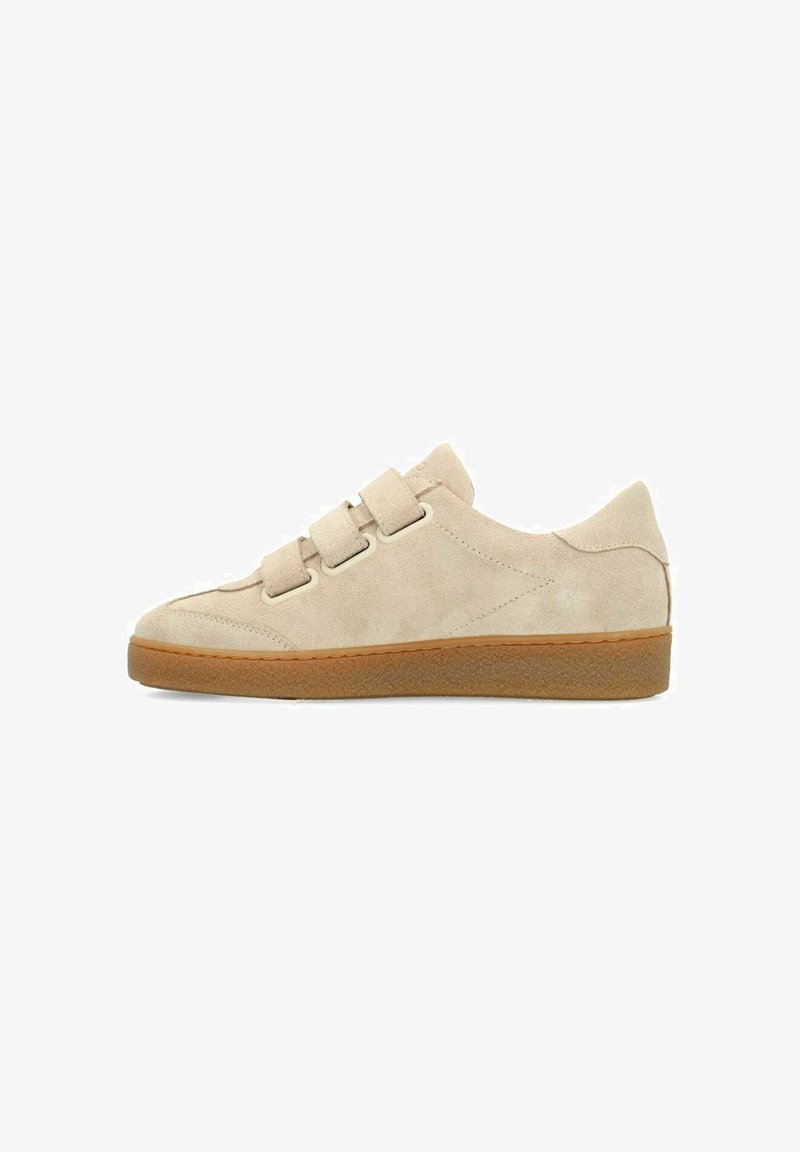 Beige suede sneaker with a round toe, three adjustable hook-and-loop straps, and a rubber sole. Features a smooth texture and simple design.