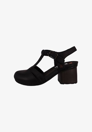 Schwarze Leder-Damensandale mit T-Riemen, verstellbarer Schnalle, geschlossenem Zehenbereich und klobigem Holzblockabsatz.