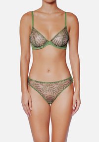 Ensemble de lingerie verte composé d'un soutien-gorge transparent et brodé de forme triangulaire, accompagné d'une culotte assortie avec des motifs floraux et une texture douce.