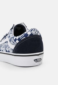 Baskets Vans bleu marine et blanches avec motif à damier et logos "Off The Wall", vues de dos sur fond blanc.