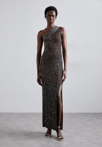 Asymmetrisches langes schwarzes Kleid mit silberner Perlenstickerei, mit einem seitlichen Schlitz und strukturiertem Stoff, betont durch einen einzigen Schulterträger.