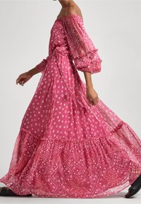 Av-with-shoulder rosa maxiklänning med puffärmar, sammanbunden midja och lager av volangkant. Har ett geometriskt och blommigt mönster i olika nyanser.