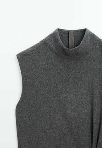 Pull sans manches en laine gris foncé avec un col rond haut et une boucle en tissu noire à l'intérieur du col.