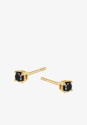 Złote kolczyki stud mają okrągłe czarne kamienie w czteropunktowym osadzeniu. Sztyfty są proste i smukłe, co podkreśla minimalistyczny design.